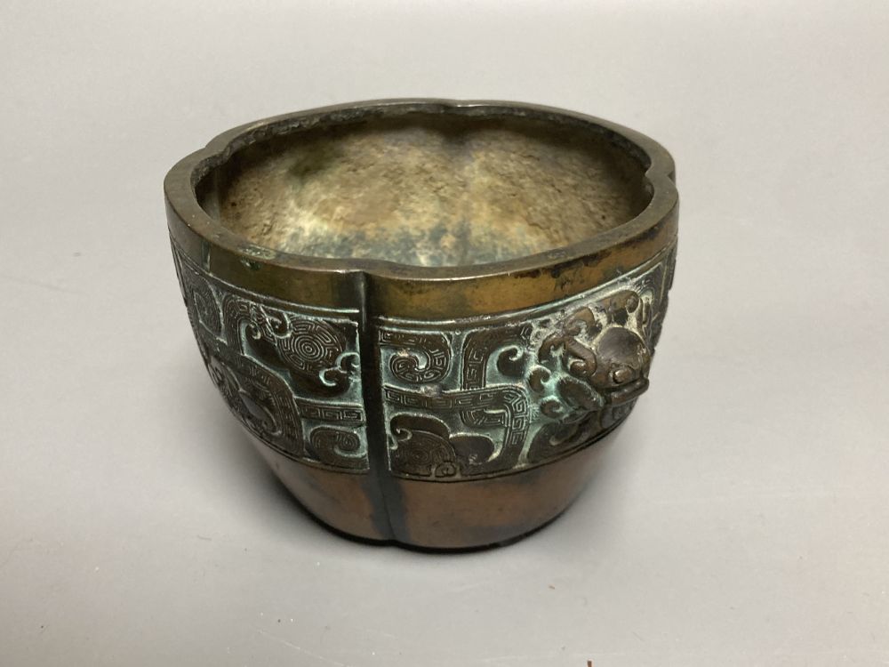 A Chinese bronze lobed censer, 18th century, archaistic cast band, on four disc feet, 11cm diameter